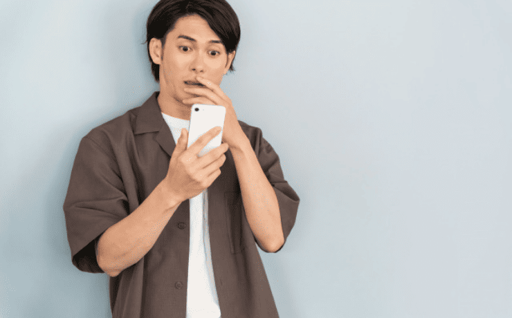 スマホを見て驚く男性
