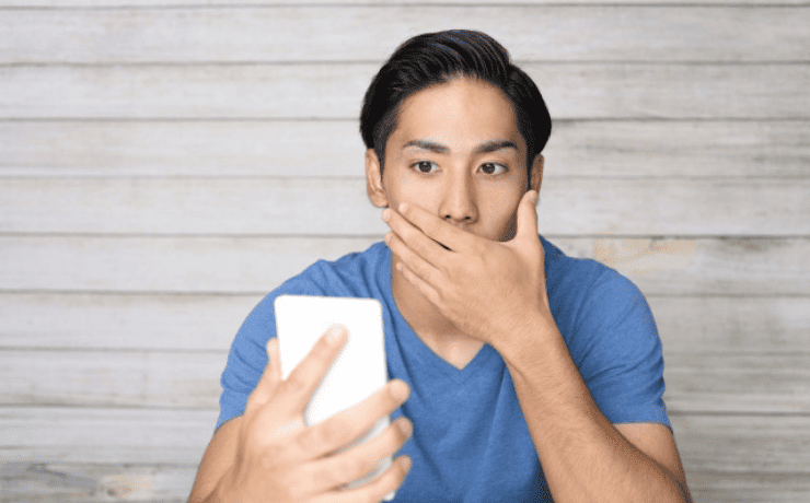 スマホを見て驚く男性