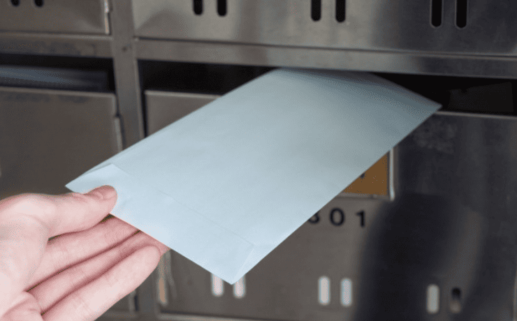 封筒をポストに入れる様子