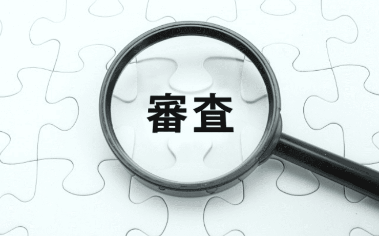 「審査」の文字を覗く虫眼鏡