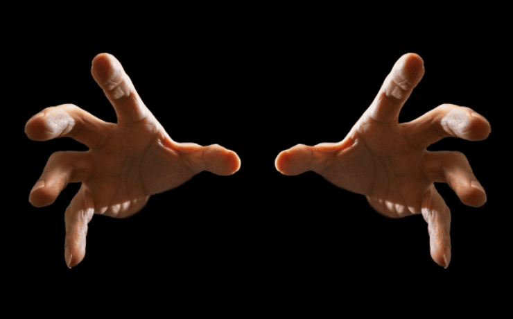 暗闇から伸びる両手のイメージ