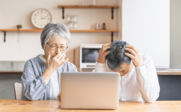 パソコン画面を見て泣き悩む老夫婦