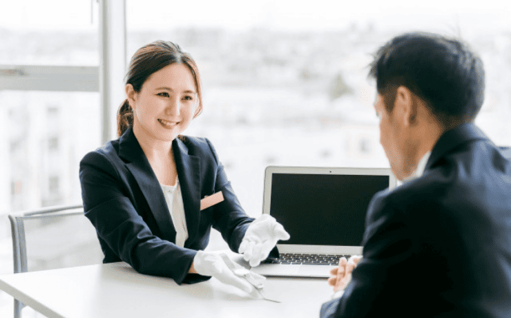 男性に腕時計を見せる質屋の女性