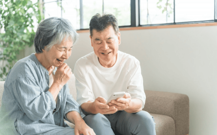スマホを見て笑う老夫婦