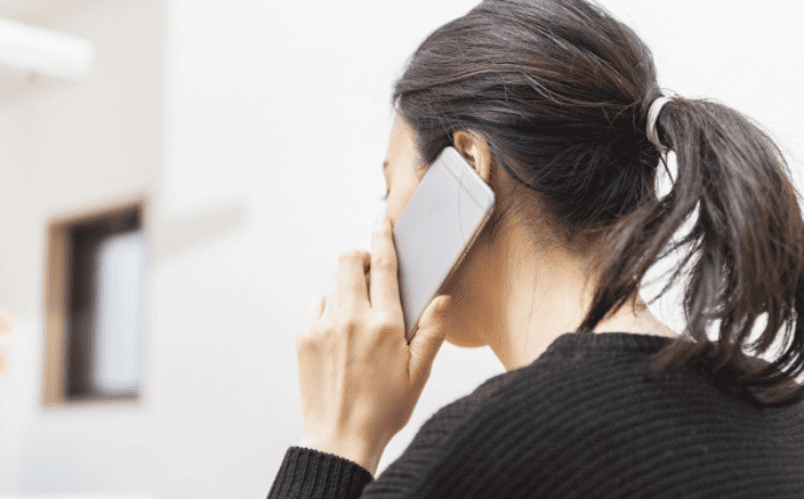 スマホ通話する女性の後ろ姿