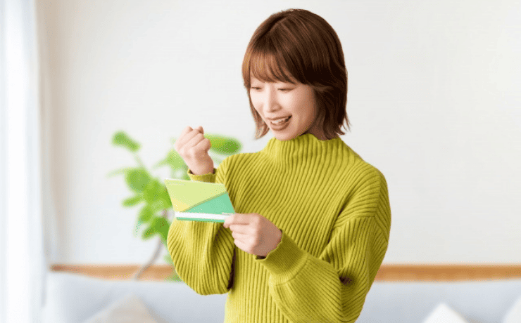 通帳を見てガッツポーズする女性