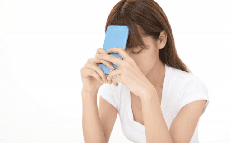 スマホを見て落ち込む女性