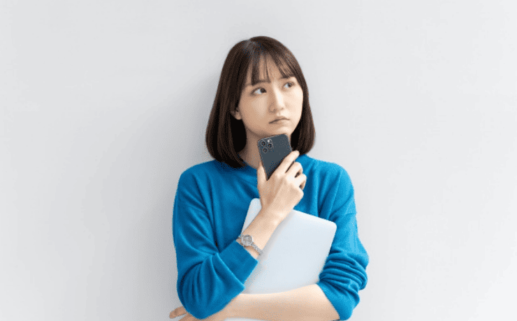 スマホを持ち悩む女性