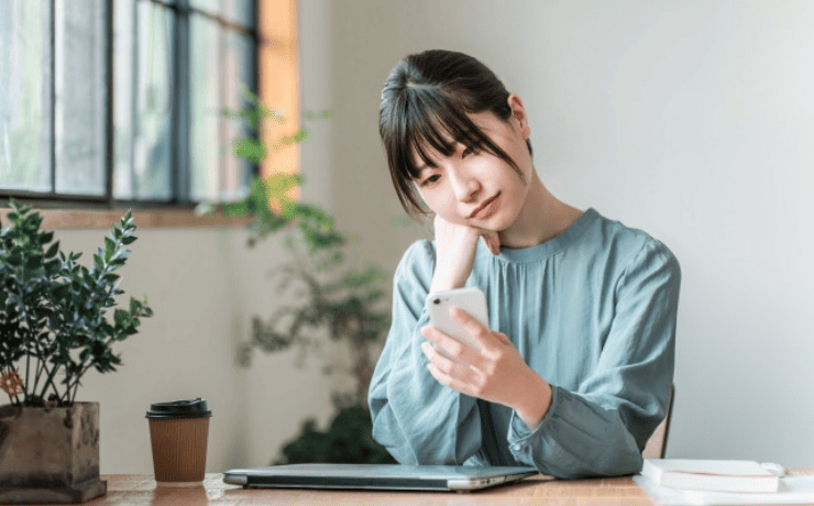 スマホを見て悩む女性