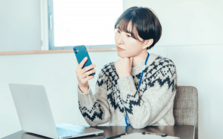スマホを見て悩む女性