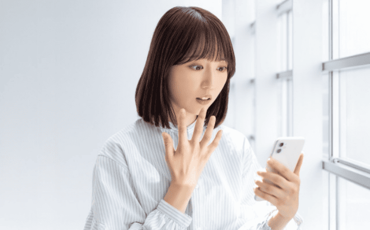 スマホを見て驚く女性
