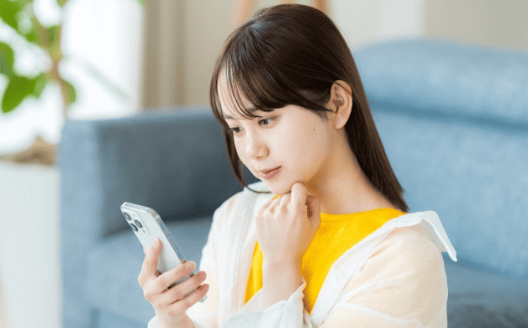 スマホを見て考える女性