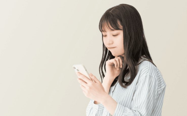 スマホを見て考える女性