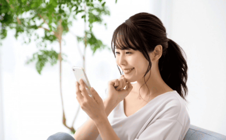 スマホを見て笑顔の女性
