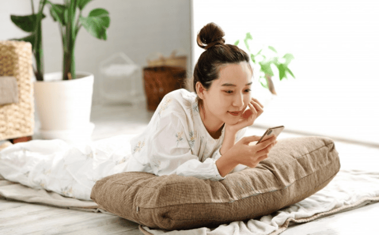 寝そべりスマホを見る女性
