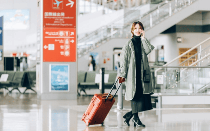 通話しながらキャリーケースを引く女性