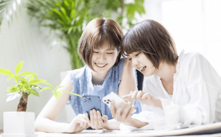 楽しげにスマホを操作する2人の女性