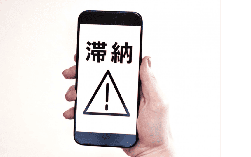 スマホ画面に滞納と表示されている