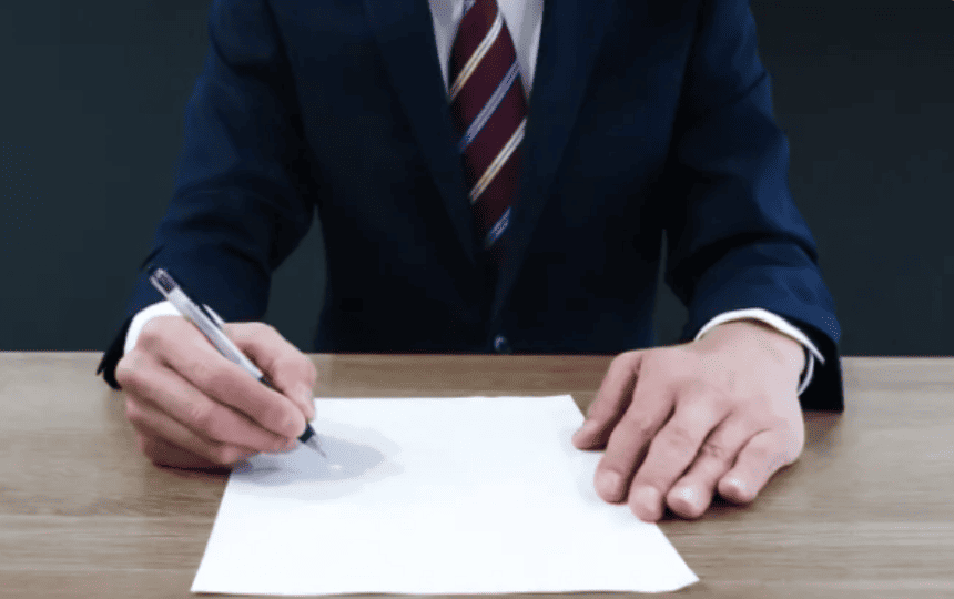 スーツ姿の男性が書類に書き込む様子