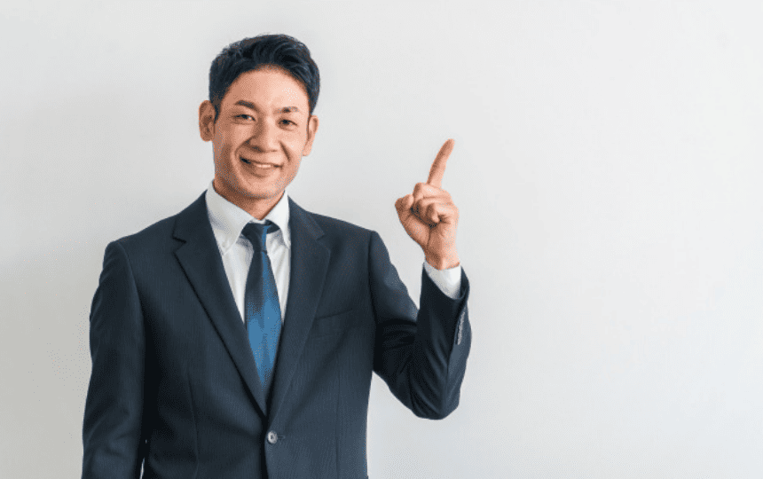 指を差す笑顔のスーツ姿の男性