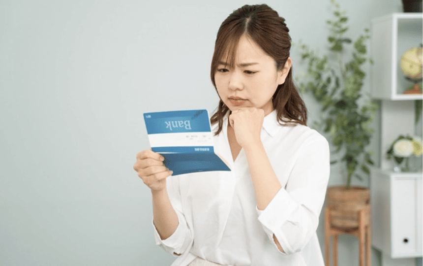 難しい顔で通帳を見る女性