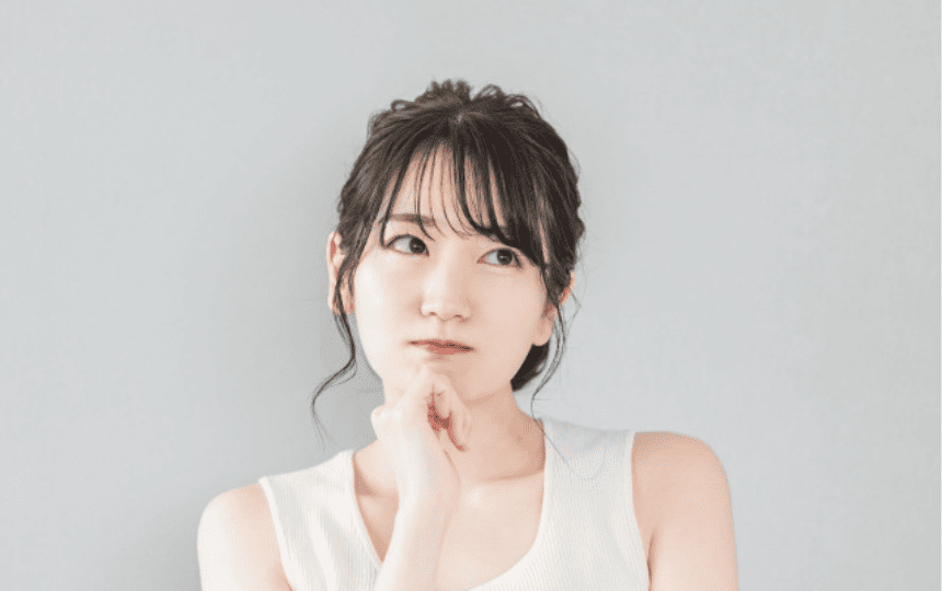 顎に手を当て悩む女性