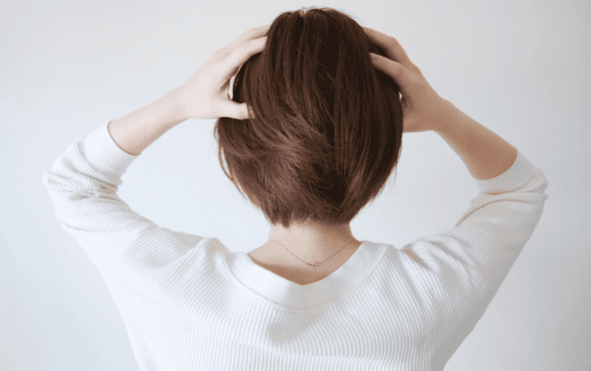 両手で頭をかかえる女性