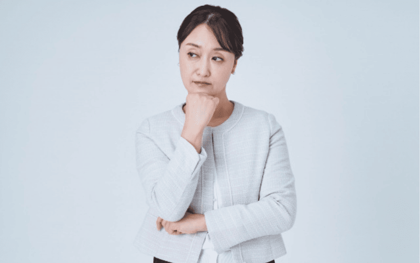 顎に手を当て悩む女性