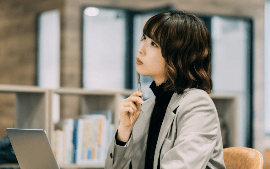 ノートパソコンの前に悩む女性