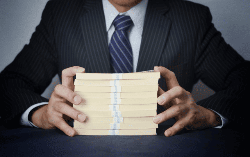 札束を持ったスーツ姿の男性
