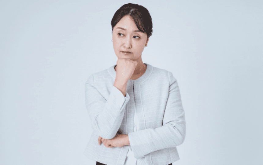 顎に手を当て悩む女性