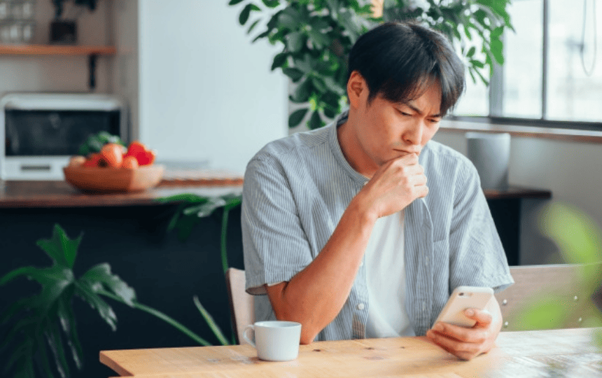 悩みがおでスマホを見る男性