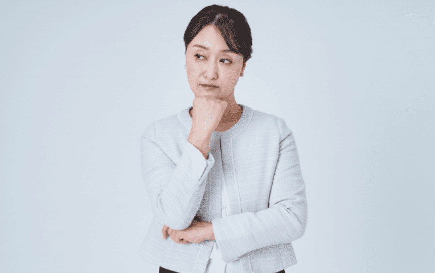 顎に手を当て悩む様子の女性