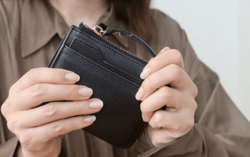 両手で財布を握る女性