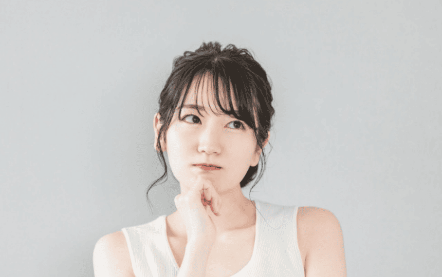 顎に手を当て悩む女性