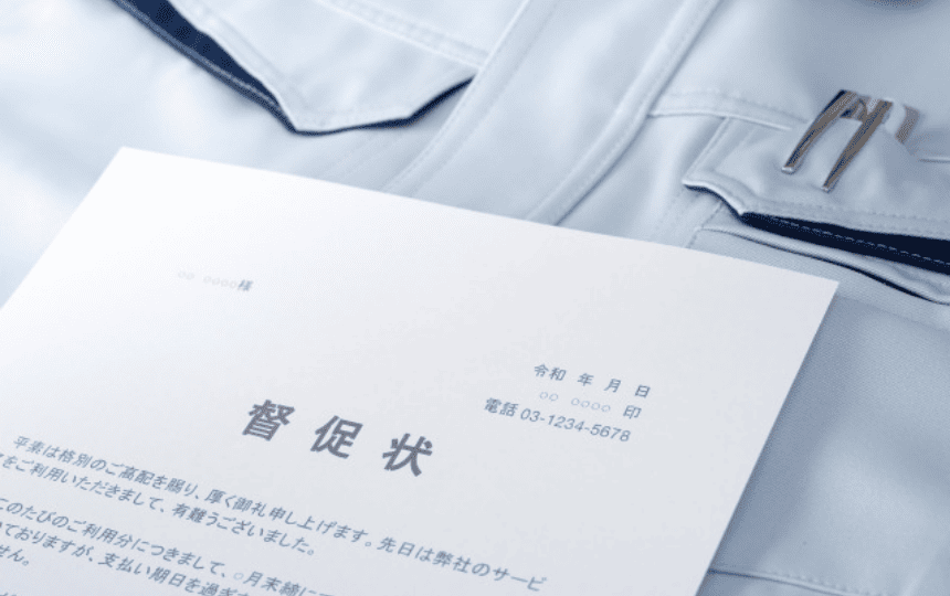 作業服の上に督促状が置かれている