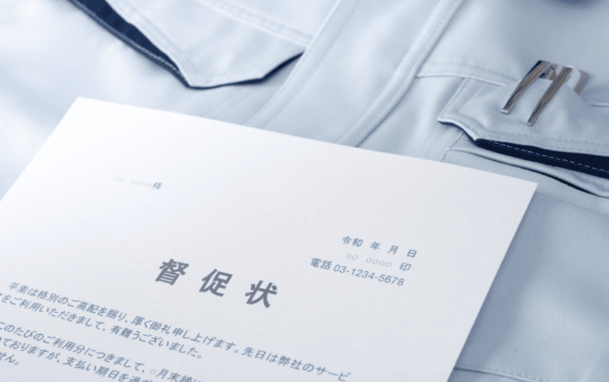 作業服の上に督促状が置かれている