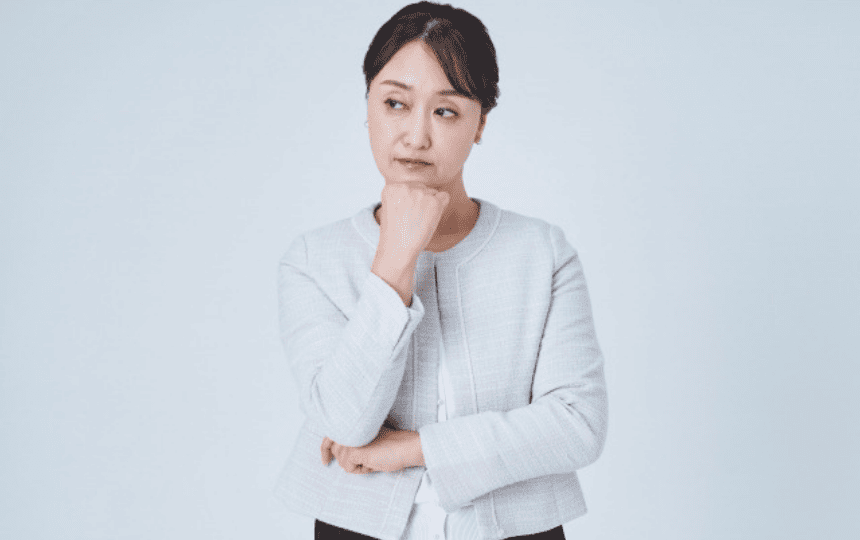 顎に手を当て悩む女性