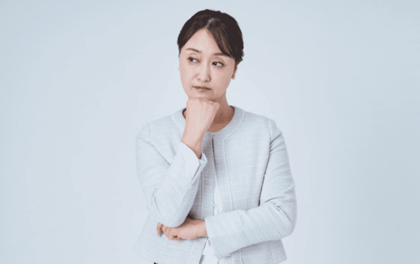 顎に手を当て悩む女性