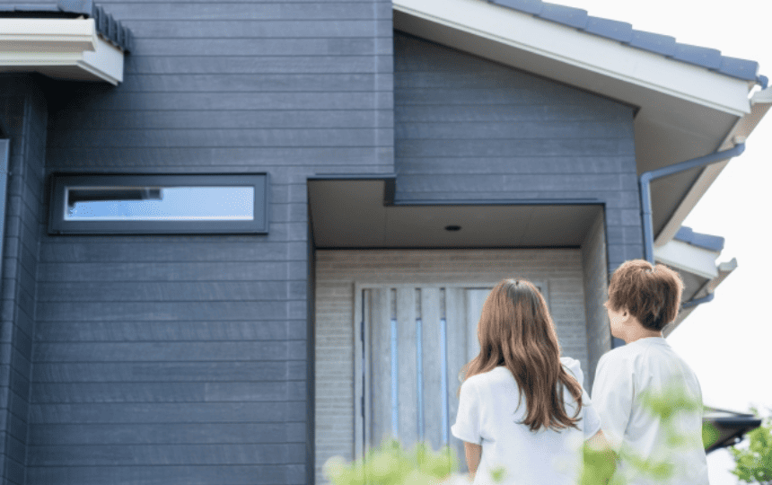 一軒家の前に立つ男女