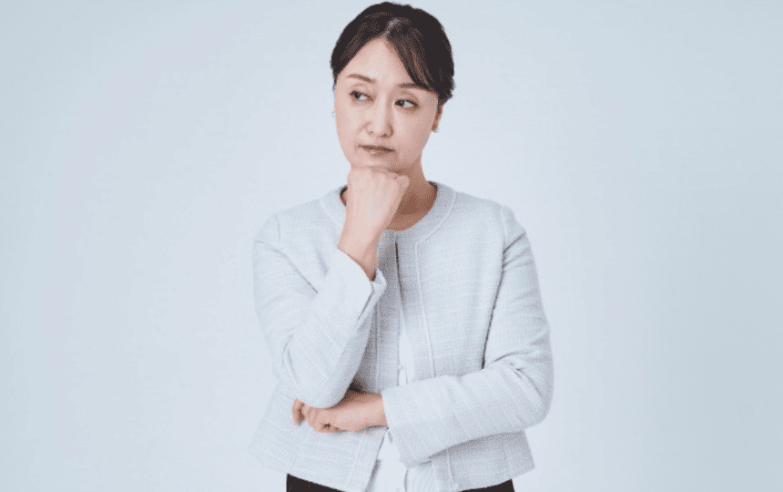 顎に手を当て悩む女性