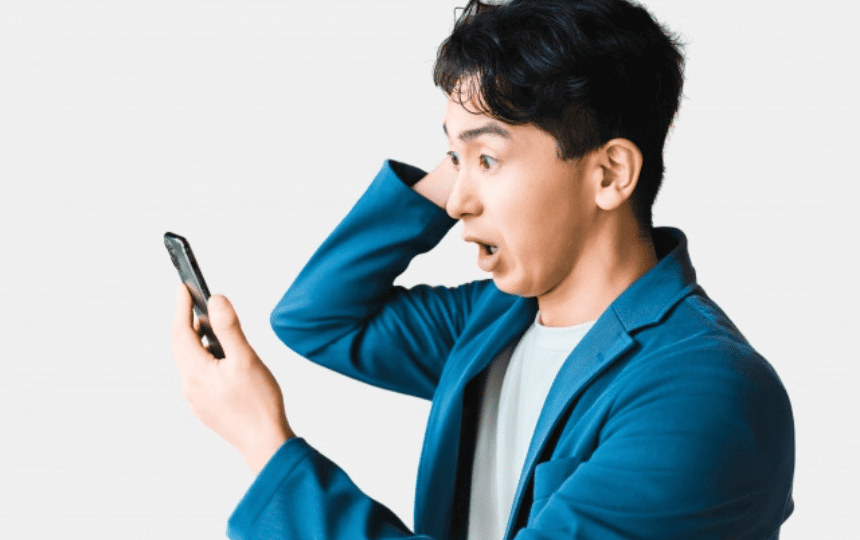 スマホを見て驚く男性