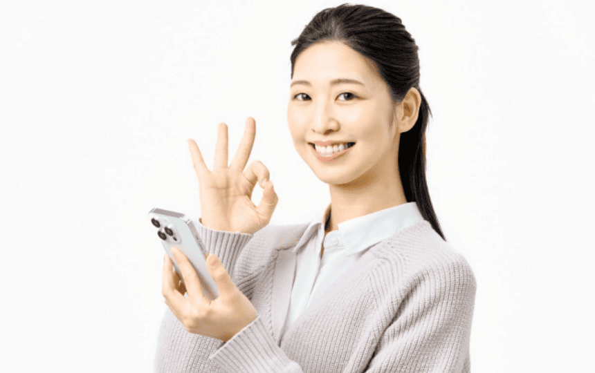 OKマークをするスマホを持った女性