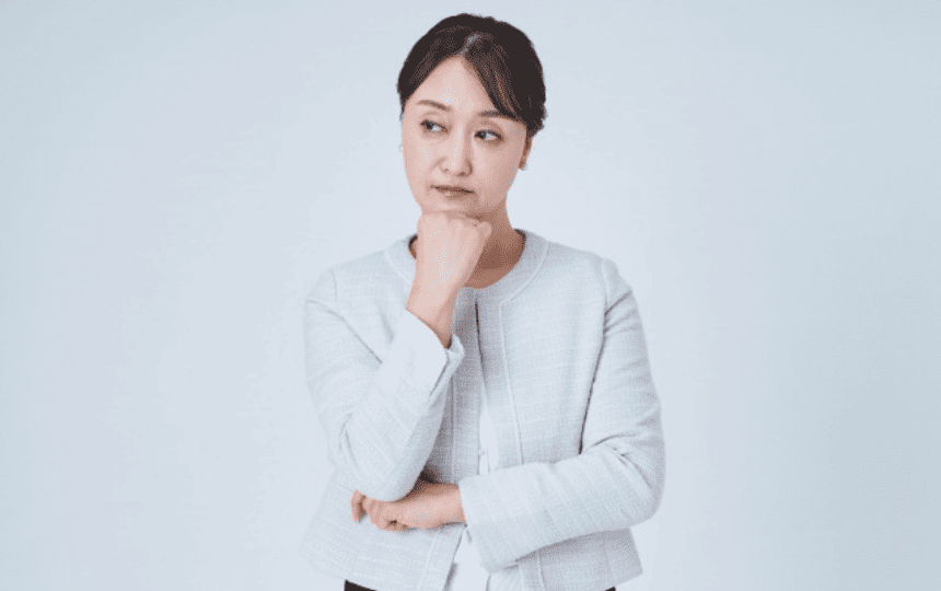 顎に手を当て悩む女性