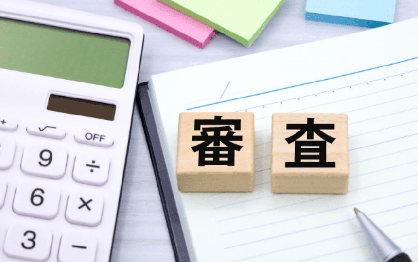 審査と書かれた積み木と電卓