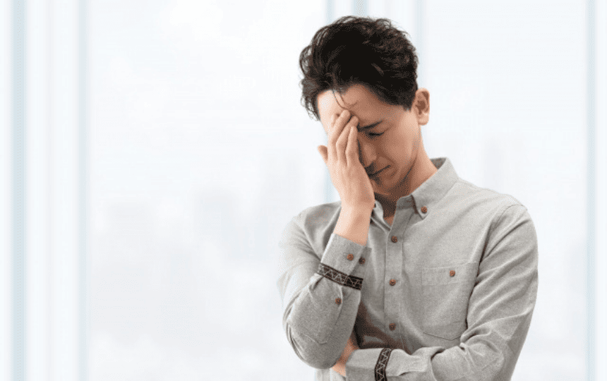 頭をかかえる男性