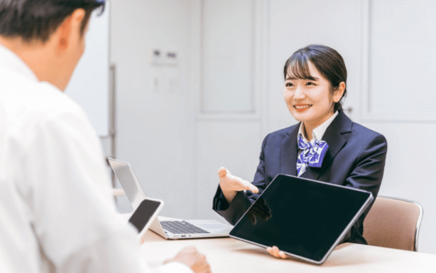 タブレットの画面を見せる窓口の女性