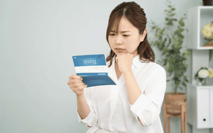 通帳を見て難しい顔をする女性