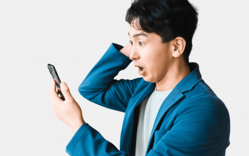 スマホを見て驚く男性