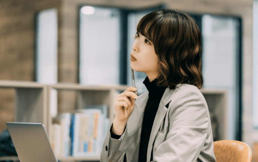 遠くを眺めて悩む女性